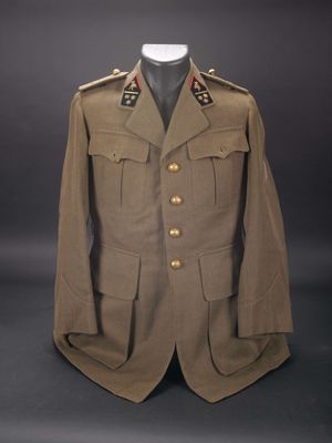 une vieille veste militaire à boutons posée sur un mannequin