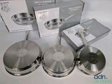 three stainless steel frying pans sitting on top of a white table
