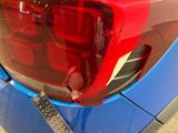 a close up of a red tail light on a blue car