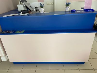 un comptoir d'accueil bleu et blanc dans une petite pièce