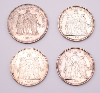 four different british coins are shown in a row on a white surface
