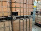 une grande quantité de fûts empilés sur des palettes dans un entrepôt