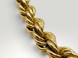 a close up of a gold necklace on a white surface