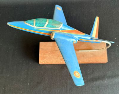 un petit avion en jouet posé sur un socle en bois