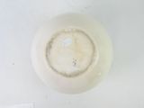 a white bowl with a small amount of liquid in it
