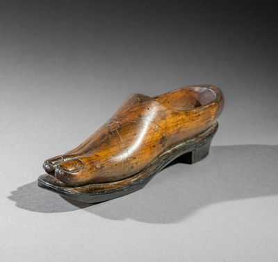 an old wooden shoe is sitting on top of a table