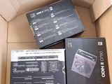 trois boîtes contenant des gadgets électroniques, empilées les unes sur les autres dans un carton