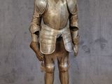 une statue représentant un homme en armure posée sur une table en bois
