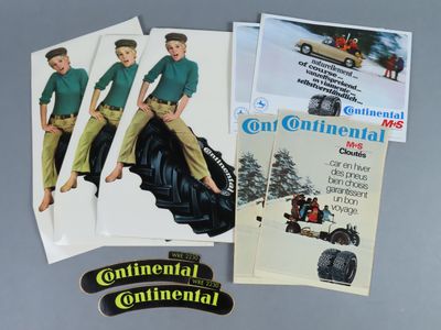 quelques vieilles publicités sont posées sur une table, à côté d'une paire d'autocollants
