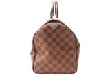 a brown and black checkered purse with a metal handle