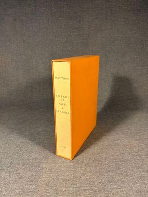 an orange book sitting on top of a table next to a black table