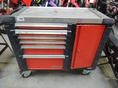 a red and black tool box on wheels in a garage