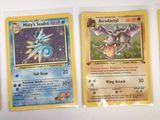 four different pokemon cards are lined up on a white surface