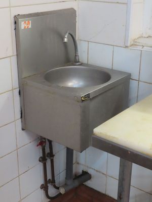 un lavabo situé dans un coin d'une salle de bains dotée d'une fenêtre