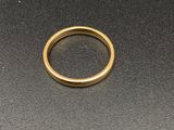 gros plan d'une bague en or sur une surface noire