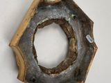 a metal object with a hole in it on a white surface
