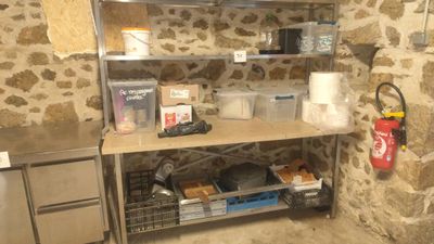 a kitchen with a stone wall and stainless steel shelvings