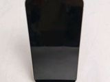a black cell phone sitting on a stand on a table