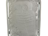 an image of a white glass owl on a silver tray