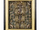 un tableau représentant des fleurs et des feuilles, dans un cadre doré et noir