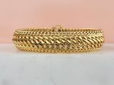 an image of a gold bracelet on a marble surface
