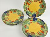 three plates with different designs on them sitting on a white surface