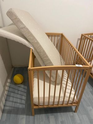 a baby crib that has a mattress in it