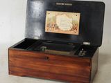 a wooden box that has a music box inside of it
