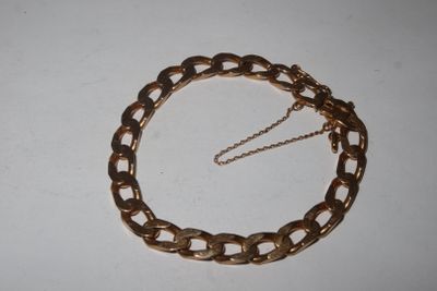 a close up of a gold chain bracelet on a white surface