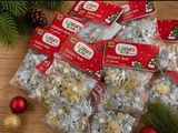 many bags of christmas candy sitting on a table