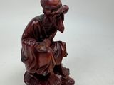 an image of a figurine of a man sitting on a rock