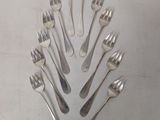 a lot of forks arranged in a circle on the table