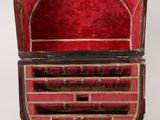 an old wooden box with red velvet linings and a metal handle