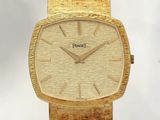 une montre-bracelet en or avec un cadran blanc et un bracelet en or