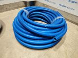 un tuyau bleu posé par terre près d'un mur