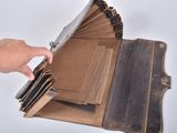a person holding a wallet that is open on a table