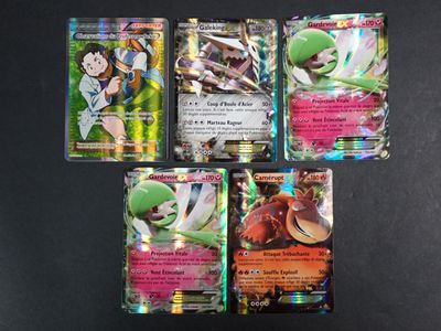 four pokemon cards are sitting on a black surface