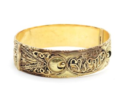 gros plan d'un bracelet en or sur fond blanc