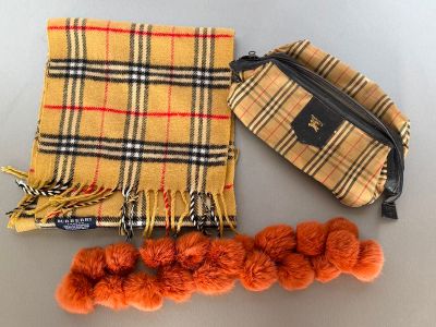 a purse, scarf, and pom poms on a table