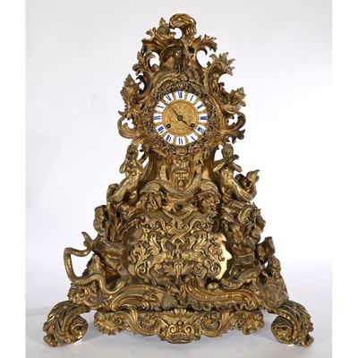 a gold clock that is sitting on top of a table