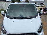 the front of a white ford transit van parked in a parking lot