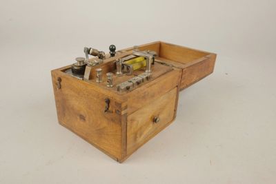 une vieille caisse en bois contenant des outils, posée sur une surface blanche