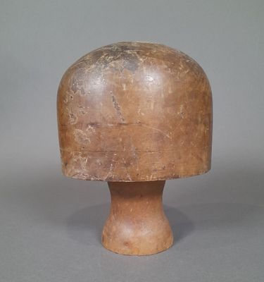 a small wooden object on a table with a gray background