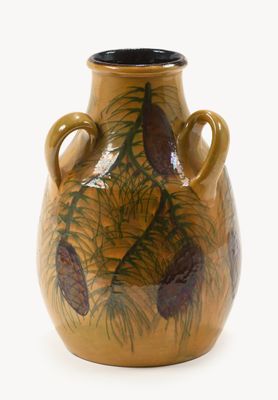 un vase marron orné de pommes de pin sur fond blanc