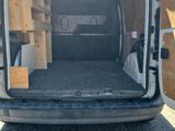 the back of a van with the door open and the bed in the back of it