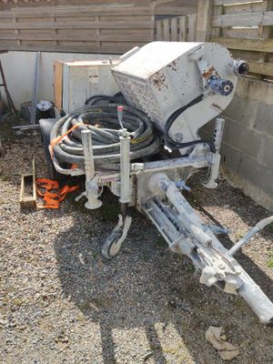une machine posée par terre à côté d'une clôture