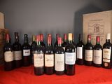 many bottles of wine sitting on a table with a red cloth