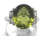 an image of a ring with a green stone surrounded by white diamonds