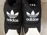 a pair of black and white adidas shoes on the floor