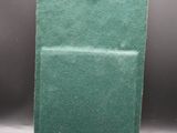 un sac vert muni d'un anneau, posé sur une table
